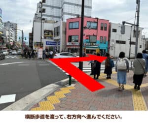 横断歩道を渡って、右方向へ進んでください。